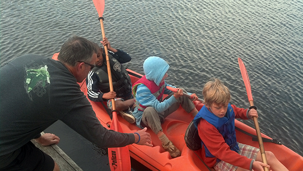 Mark Easler Helping Cameron, Elliot, and Jordan into a Boat